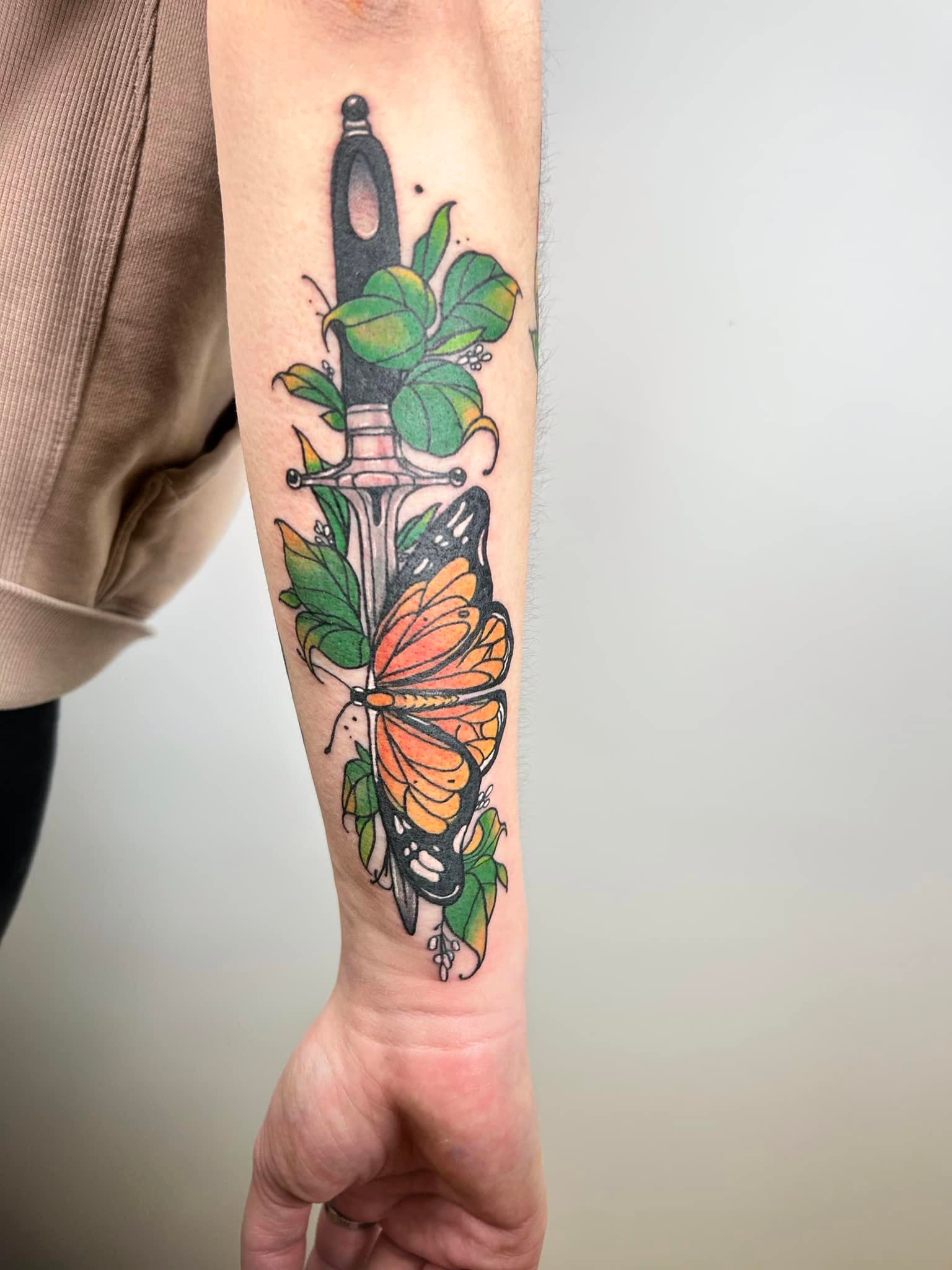 Tatouage néo-traditionnel d'une dague avec papillon monarque